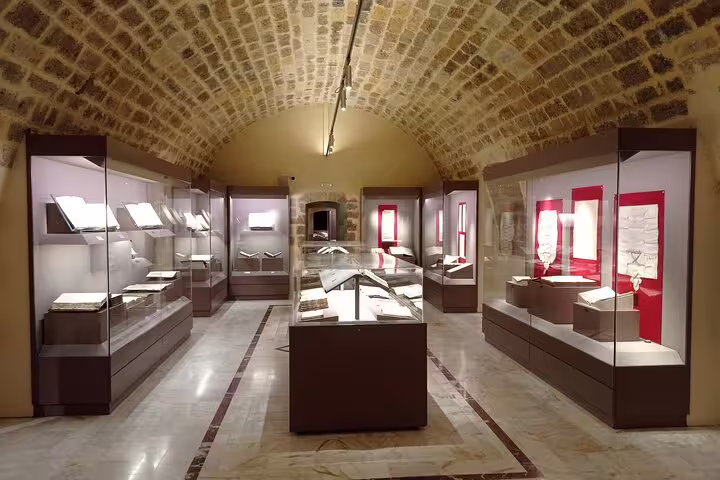 Discover ancient manuscripts and artifacts in a serene, arched exhibit room at the Lady of the Angels Monastery.