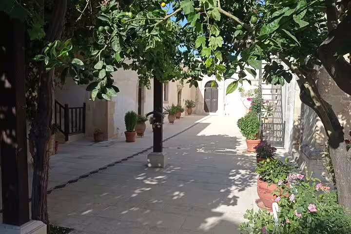Charming courtyard at Lady of the Angels Monastery with potted plants under lush greenery, ideal for peaceful retreats.