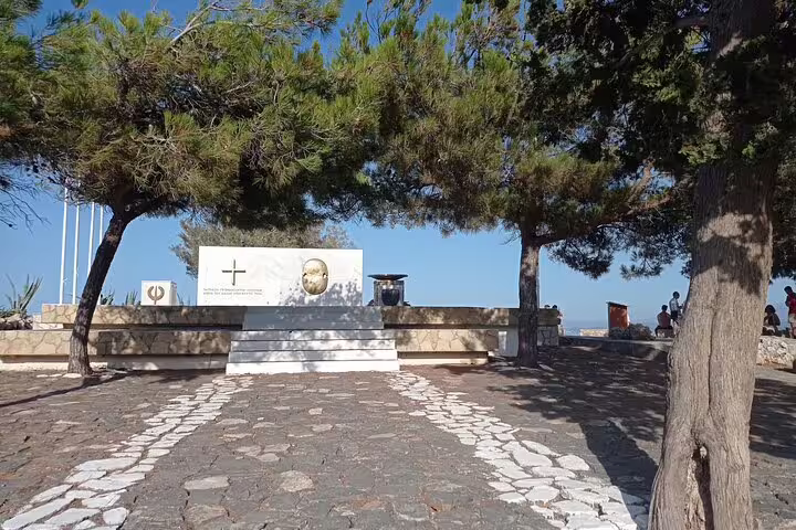Scenic view of Lady of the Angels Monastery surrounded by lush trees and stone pathways in serene Falasarna.