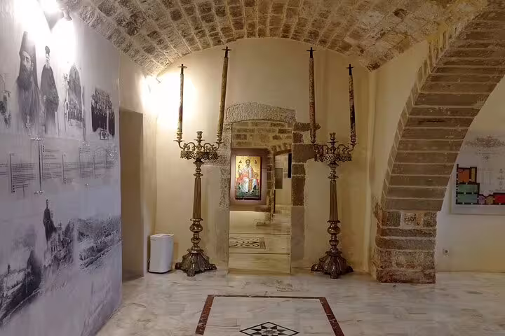 Interior view of Lady of the Angels Monastery showcasing ornate candelabras and religious artwork in a stone archway.