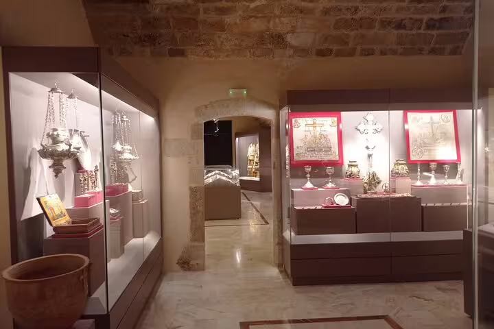 Illuminated displays of religious artifacts in Lady of the Angels Monastery showcase historical treasures and sacred relics.