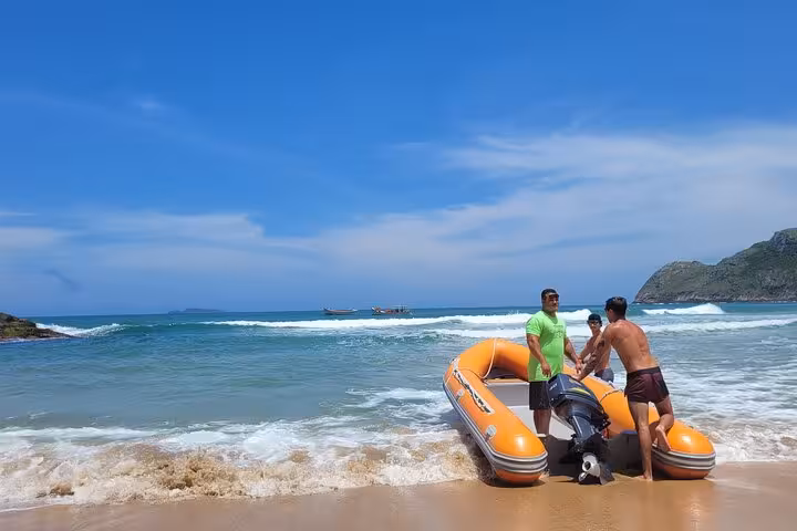 Adventurers preparing an inflatable boat on the sunny shores of Lagoinha do Leste beach.