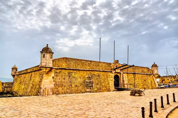 Ancient fort with stone walls under a cloudy sky in Lagos, a highlight on the private city walking tour.