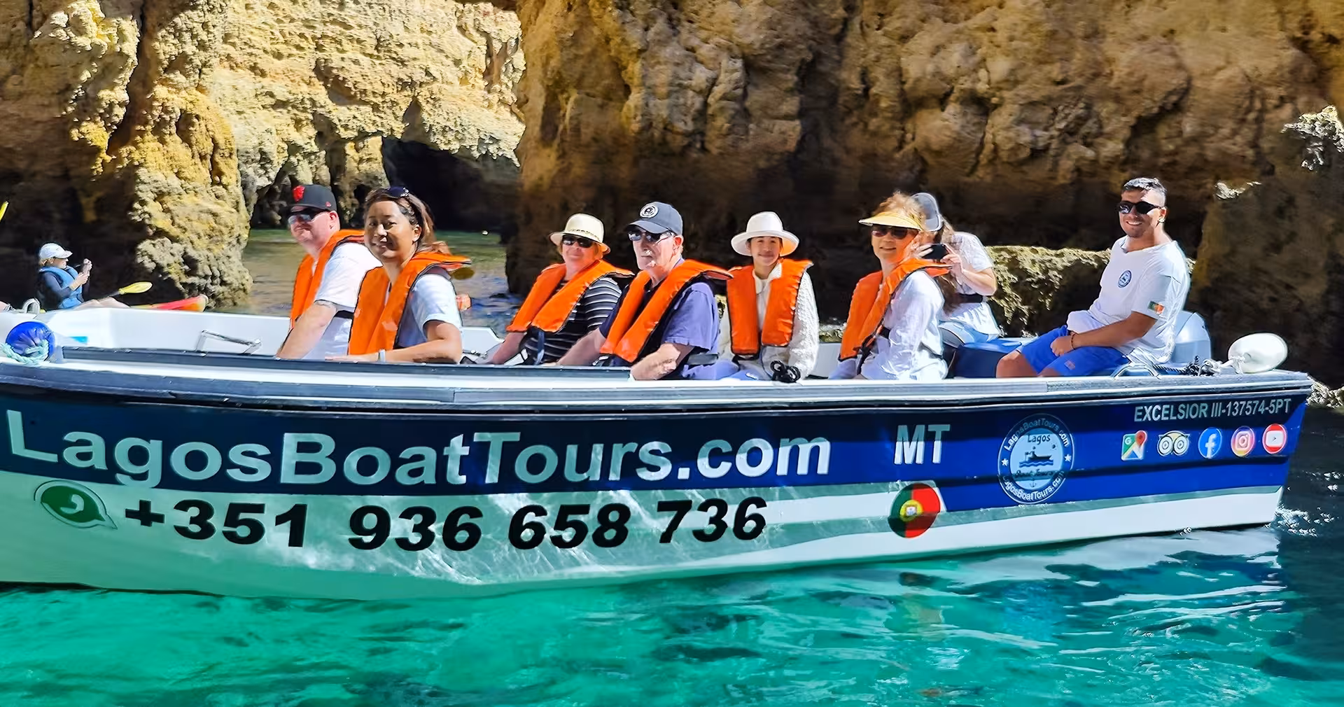 Happy group on Lagos Boat Tours vessel exploring turquoise waters and rock formations at Ponta da Piedade caves in Algarve