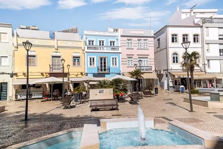 Charming Lagos square with colorful buildings and a central fountain, ideal for a Hello Lagos city walk tour.