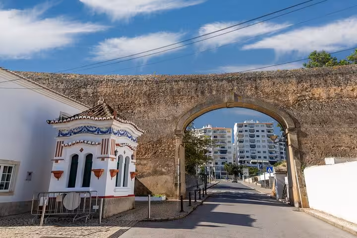 Historic stone archway and quaint building in Lagos, showcasing architectural beauty on a guided city walk adventure.