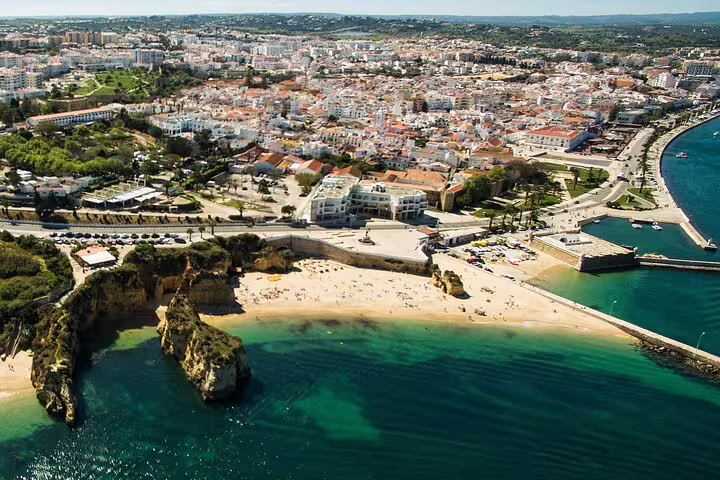 Aerial view of Lagos beach and cityscape in Algarve, Portugal, featuring stunning coastline on a private tour from Lisbon.