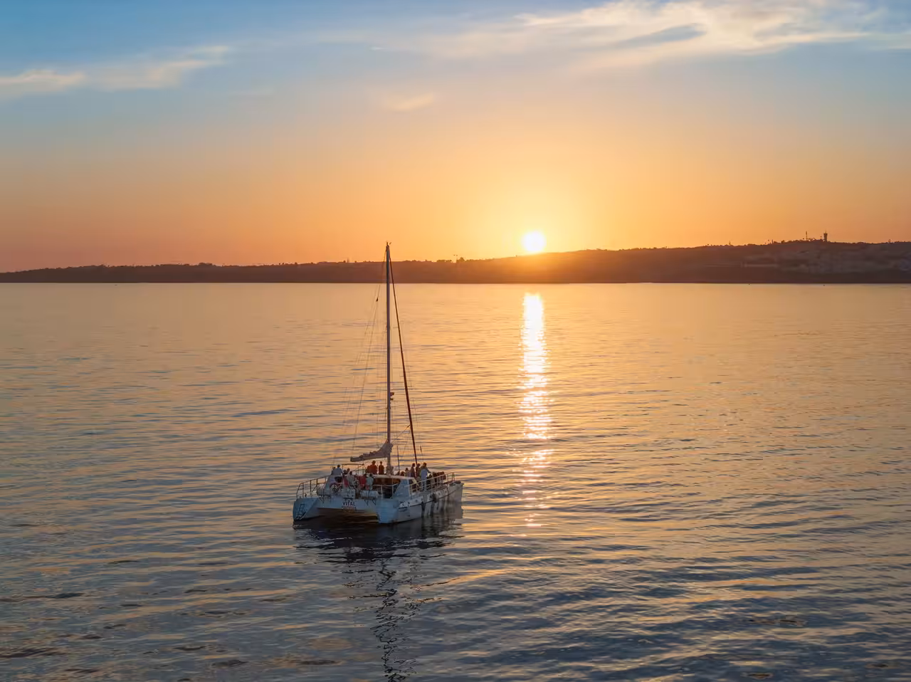 Lagos sunset catamaran cruise sailing on calm golden waters with stunning orange sky views