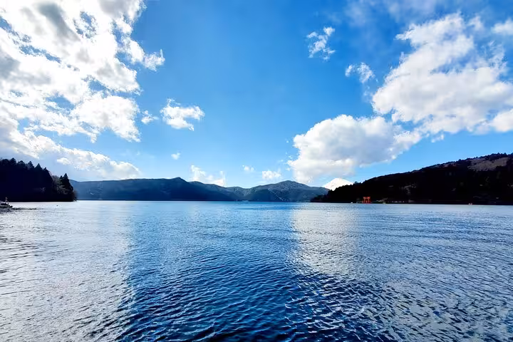 Expansive view of Lake Ashi under a clear blue sky, ideal for sightseeing on a Hakone guided tour.