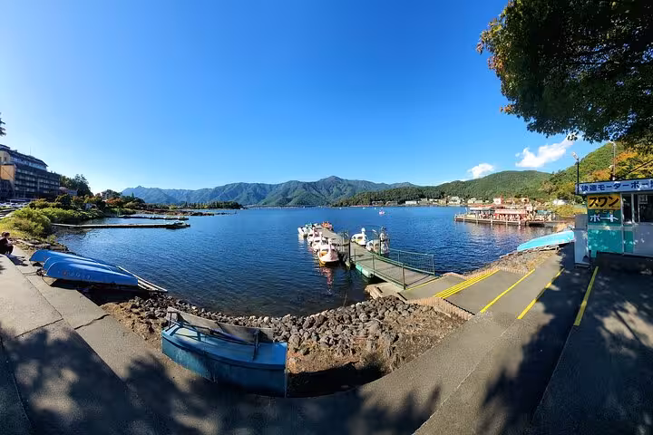 Picturesque harbor scene at Lake Ashi with boats and mountain backdrop, featured in the 2-day Hakone private tour.
