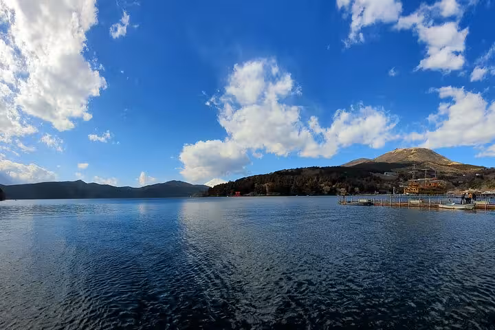 Serene Lake Ashi view under a bright blue sky, a highlight of the Tokyo to Hakone guided tour.