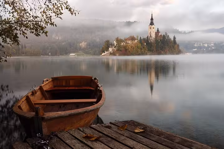 Traditional wooden boat on Lake Bled with island church, a highlight of Slovenia day tour from Ljubljana