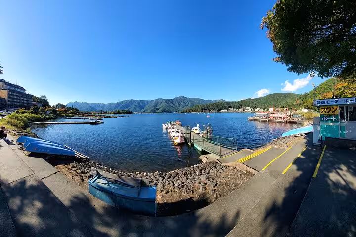 Scenic view of Lake Kawaguchi with boats and mountains, featured in Tokyo to Mt. Fuji customizable private tour.