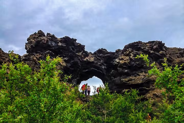 Tourists exploring the natural lava formations of Dimmuborgir in Lake Myvatn during a private day tour.