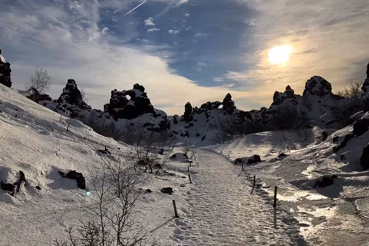 Snow-covered volcanic formations under a bright sun at Lake Myvatn, featured in the Akureyri tour itinerary.