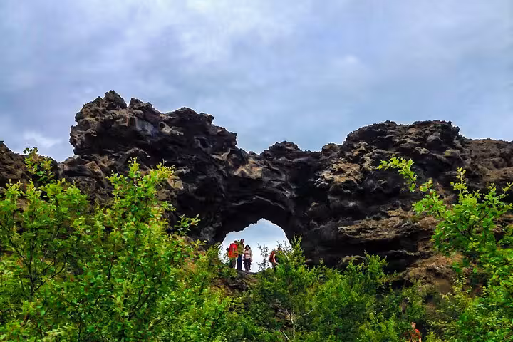 Dramatic lava rock formations at Lake Myvatn, surrounded by lush greenery, ideal for private tours from Akureyri.