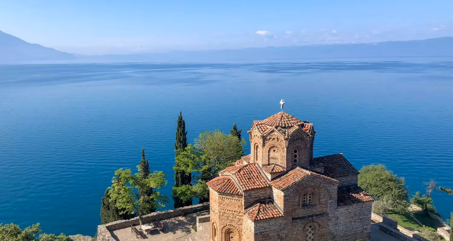 Scenic view of Lake Ohrid with historic church on the Balkan tour route.