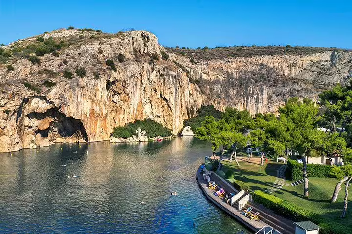 Scenic view of Lake Vouliagmeni's cliffs and lush surroundings, a highlight on trips from Athens to Cape Sounion.