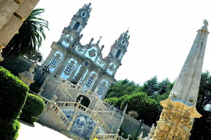 Baroque architecture of Lamego Sanctuary with intricate stonework and a tall obelisk in the foreground.