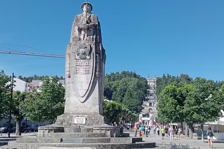 Historic statue in Lamego's main square with the Sanctuary of Our Lady of Remedies in the background.