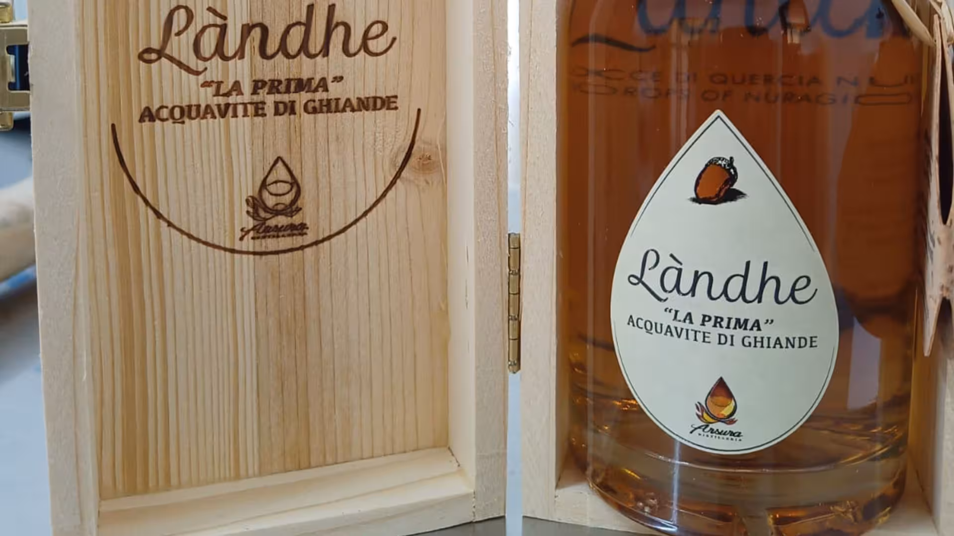 Close-up of Låndhe acorn distillate bottle in wooden box, featured in Tempio Pausania tasting tour.