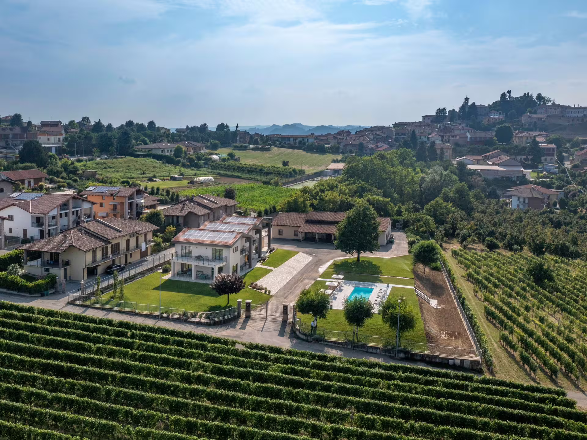 Aerial view of lush vineyards and charming countryside homes in Langhe near Alba, ideal for wine tours and tasting.