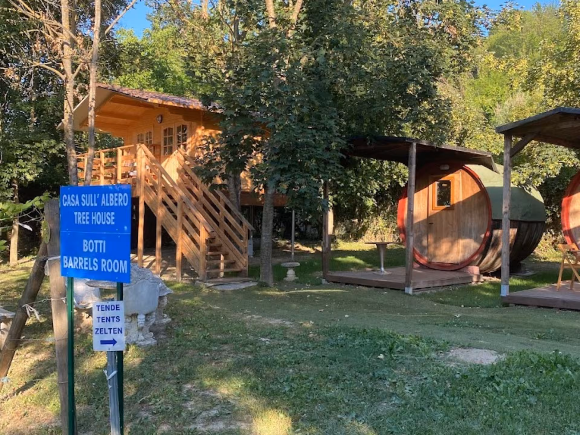 Charming tree house and barrel room accommodations in the lush greenery of Langhe, perfect for a unique wellness retreat.