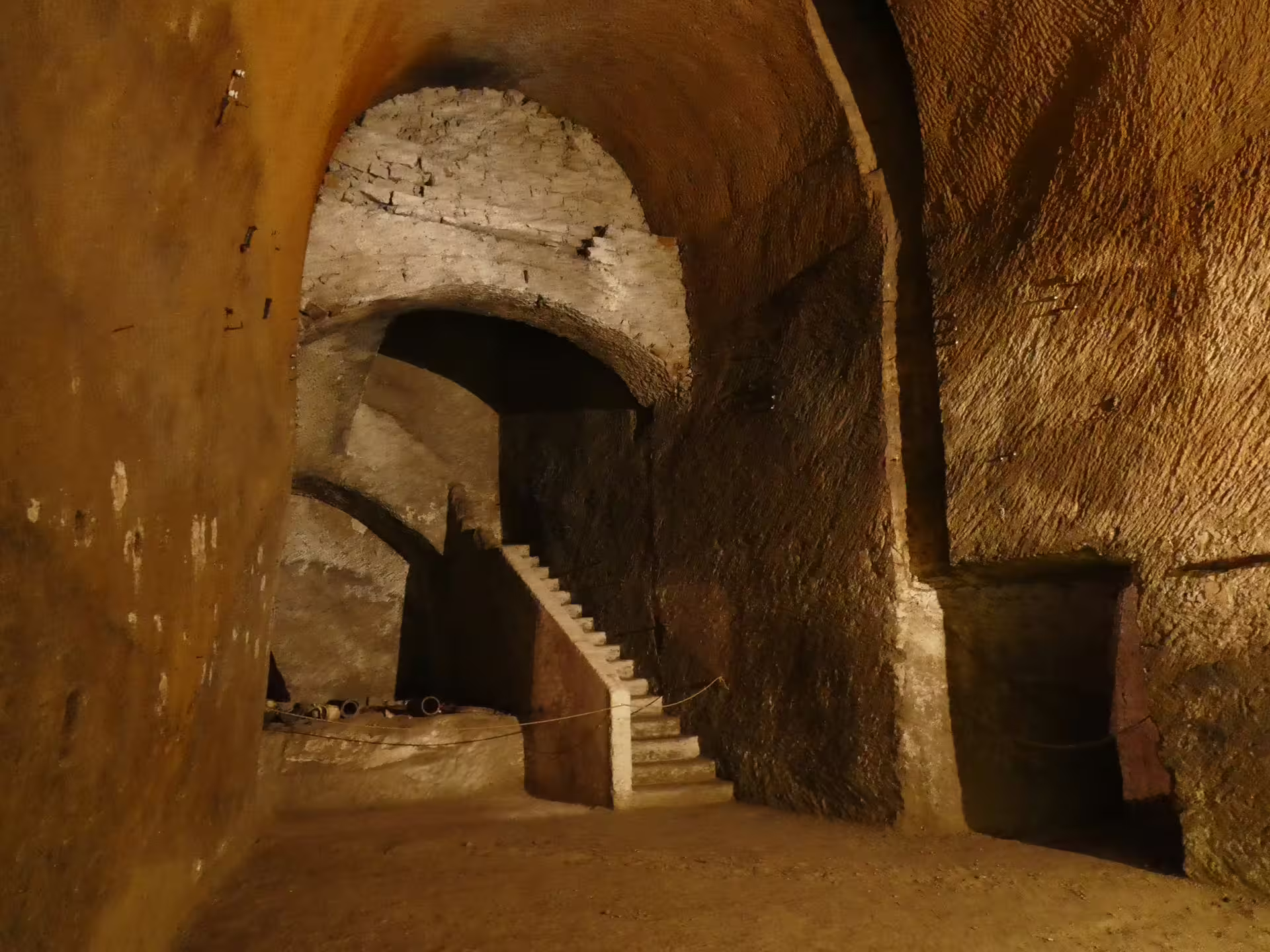 Scala illuminata nel sottosuolo del Lapis Museum a Napoli, lungo il percorso guidato del Decumano Sommerso