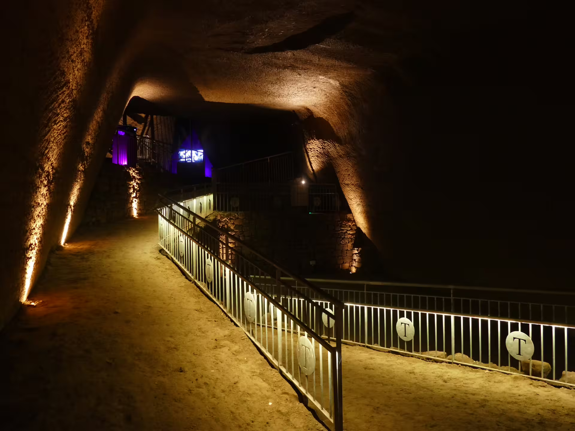 Atmospheric illuminated tunnel and walkways of the Lapis Museum Decumano Sommerso, showcasing Naples’ ancient underground route