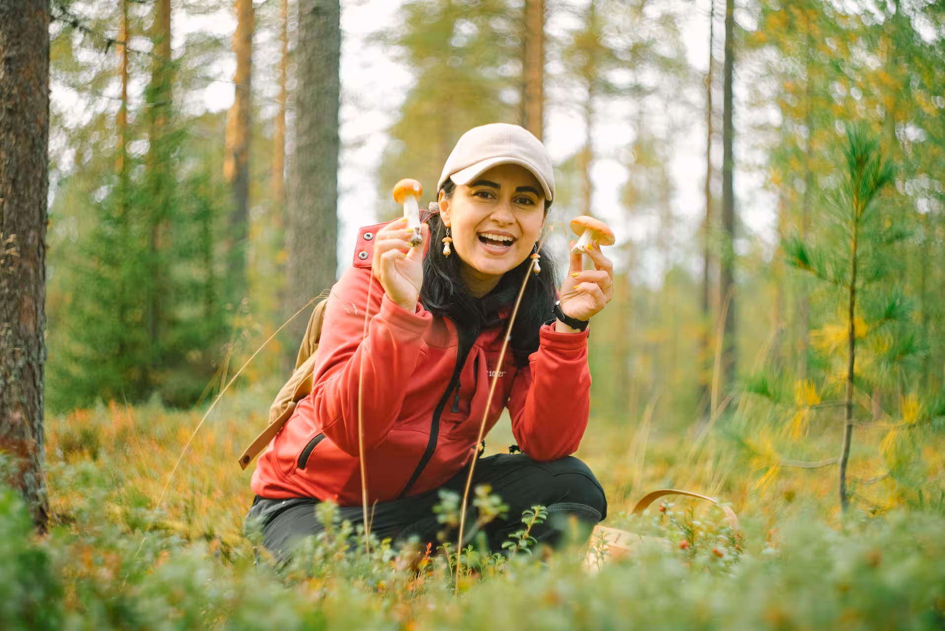 Smiling woman holding mushrooms while foraging in Lapland forest, enjoying wild berry and mushroom tour.