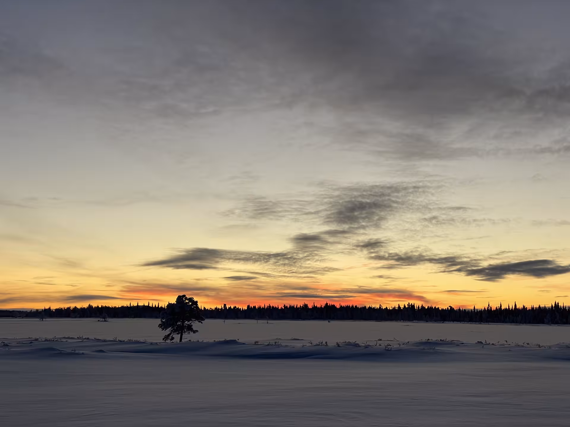 Breathtaking Lappish sunset over a snowy landscape, perfect for ice fishing and snowshoeing adventures.
