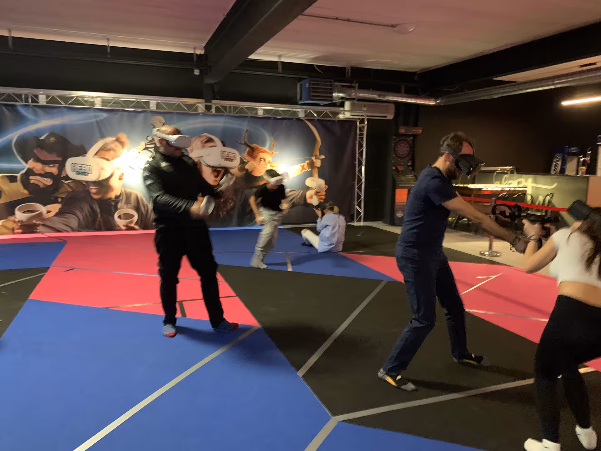 Players wearing VR headsets compete in Laser Game VR 35 free-roam arena, dodging and shooting in team play