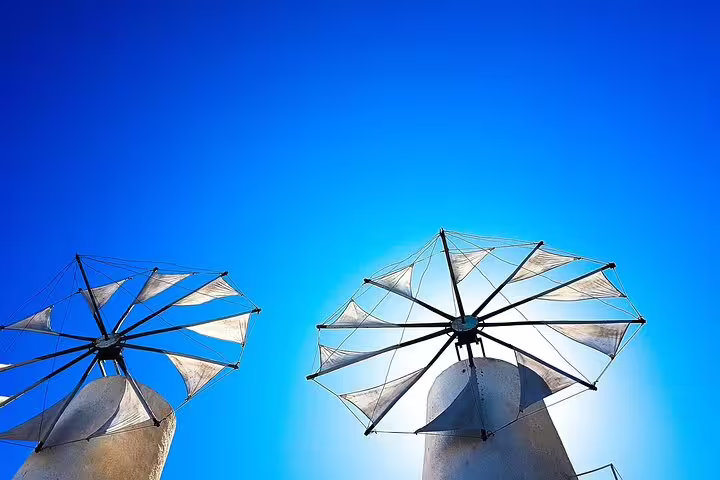 Bright blue sky over iconic windmills at the Lasithi Plateau, highlighting cultural heritage on a Chania private tour.