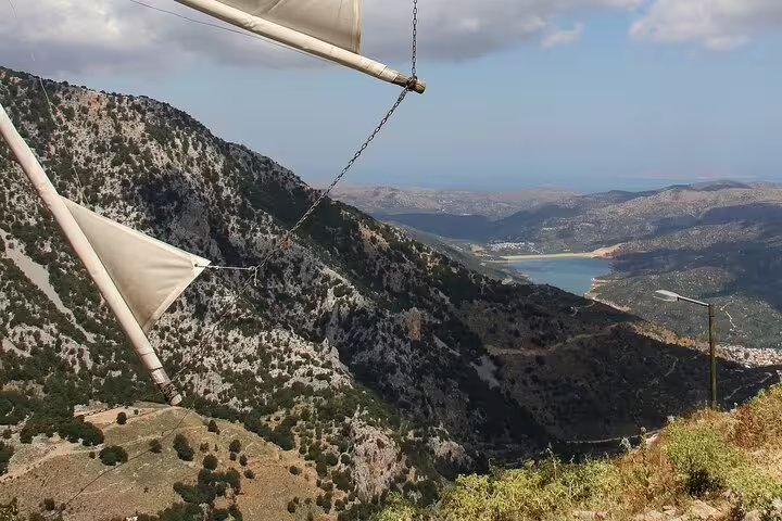 Scenic view of the Lasithi Plateau with traditional windmills and distant mountains on a private tour from Chania.