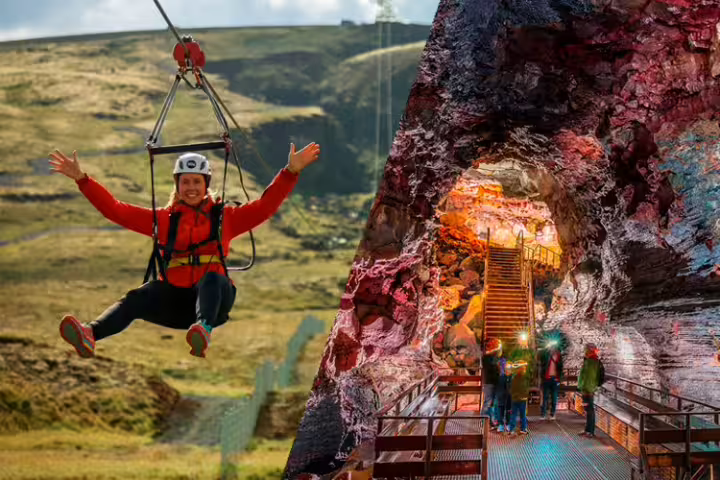 Adventurer ziplining over scenic landscape and exploring vibrant underground lava cave on thrilling Lava & Air Adventure Combo tour.