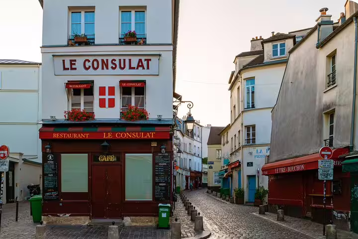 Le Consulat cafe on a cobblestone street in Montmartre, Paris, featured on a self-guided scavenger hunt tour