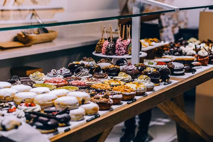 Colorful array of pastries and sweets in a Le Marais bakery, highlighting Parisian culinary delights.