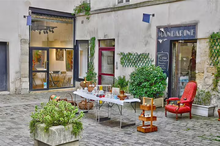 Charming Le Marais courtyard setup with vintage decor and French delicacies for private walking food tour in Paris.