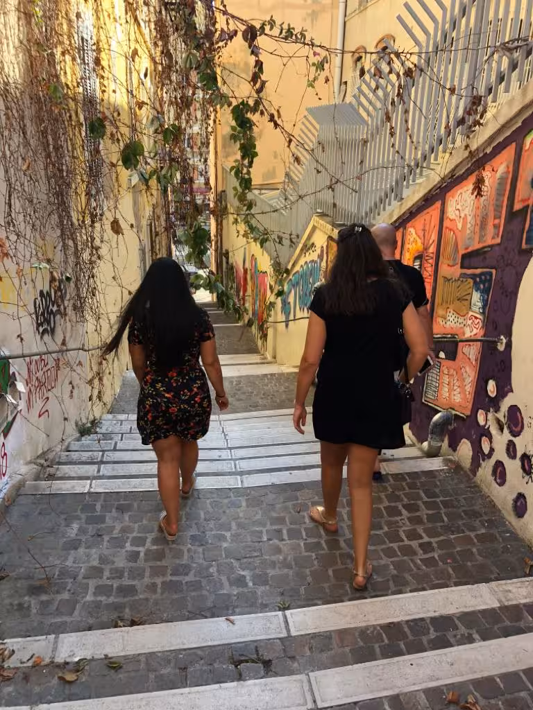 Visitors walking down graffiti-lined stairs in Le Panier, Marseille, exploring street art on a guided food tour