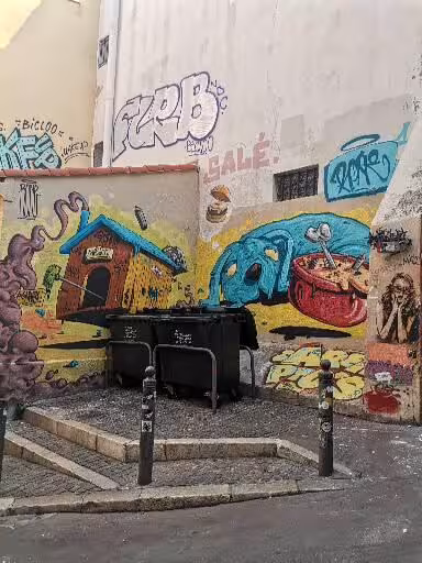 Colorful street art wall with boat and house murals in Le Panier, Marseille, on the oldest district walk