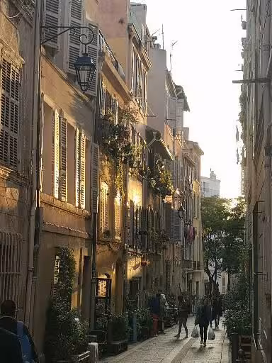 Golden hour street in Le Panier Marseille with shuttered houses and lanterns on a guided walking tour