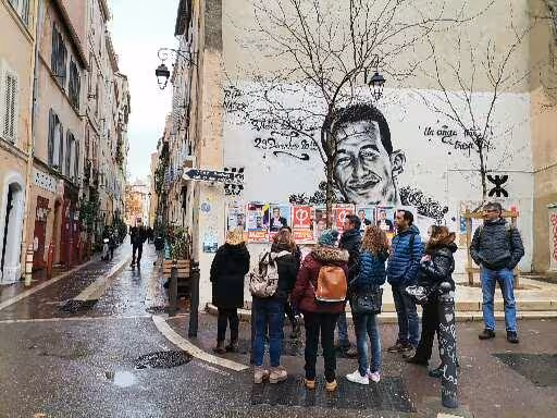 Guided walking tour group in Le Panier, Marseille, by street art mural in the oldest neighbourhood