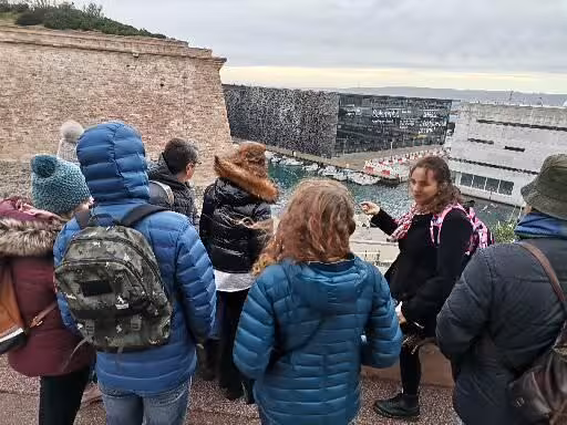 Guide leading a Le Panier walking tour group at Fort Saint-Jean viewpoint overlooking Marseille’s Old Port