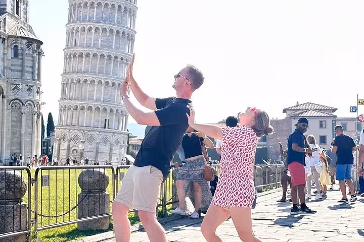 Tourists playfully pose with the Leaning Tower of Pisa during a 2-day tour from Florence to Tuscany and Cinque Terre.