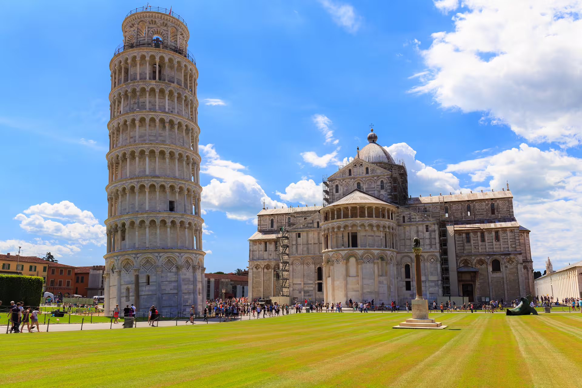 Leaning Tower of Pisa and Pisa Cathedral with tourists on green lawn during Semi-Private Florence and Pisa full-day tour from Rome
