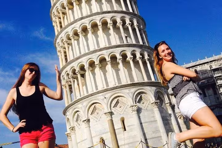 Tourists posing creatively with the Leaning Tower of Pisa during a Pisa and Cinque Terre day trip from Florence.