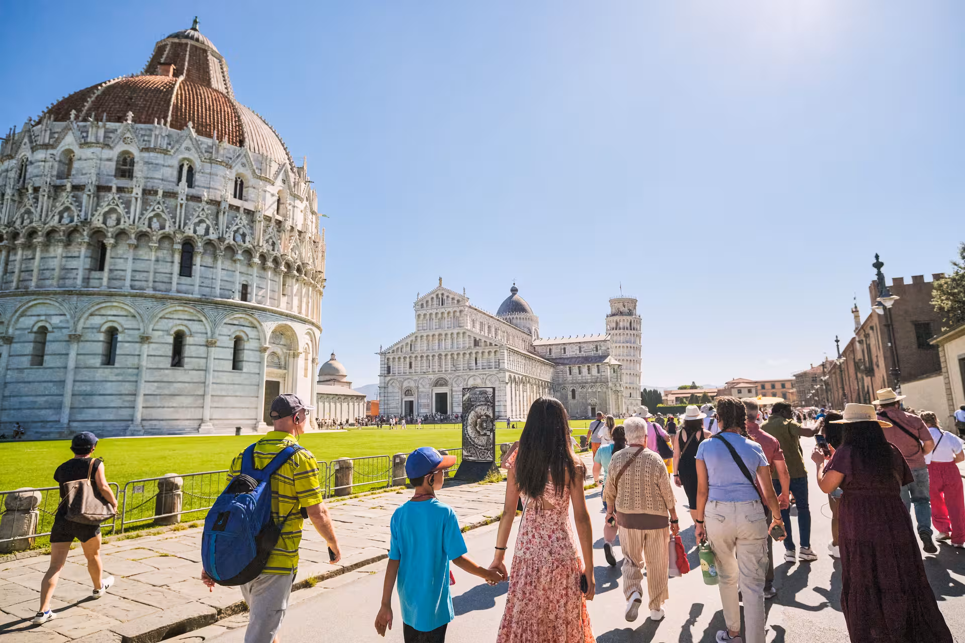 Visitors approach the Leaning Tower and Baptistery in Pisa's Piazza dei Miracoli on a guided day trip from Livorno.