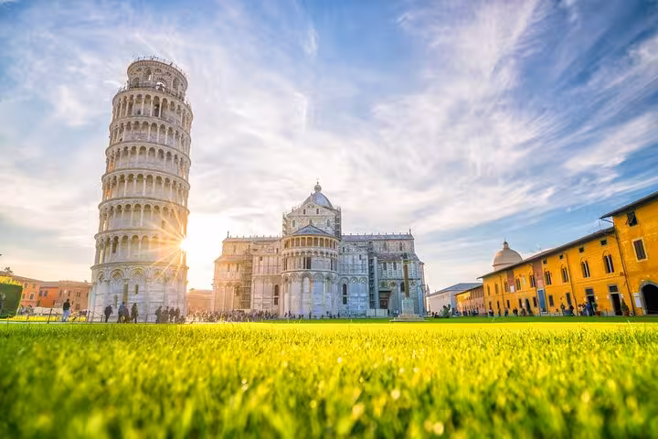 Sunset illuminating the Leaning Tower of Pisa and Cathedral, perfect for a day trip from Florence with tower tickets.