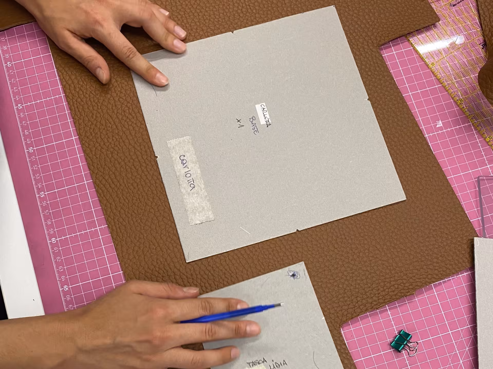 Participant marking leather pieces with templates during a hands-on wallet-making workshop in Verona.