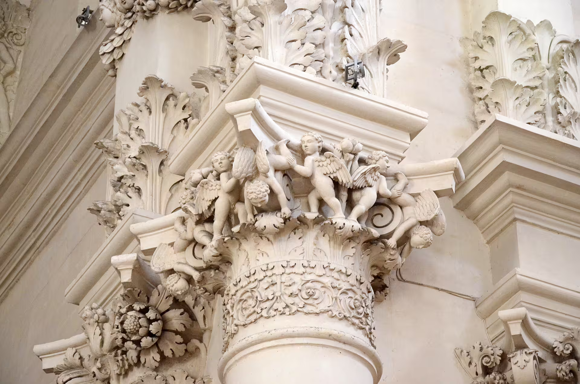 Detail of Lecce Baroque column with ornate cherub and foliage carvings on Enchanting Puglia self drive tour